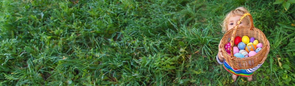 A child collects Easter eggs in the grass. Selective focus. Kid.