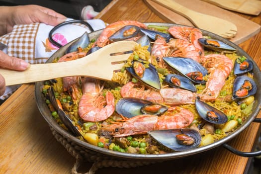 Seafood paella with shrimp and mussels in a pan, ready to be served with a wooden utensil, typical Spanish cuisine, Majorca, Balearic Islands, Spain,