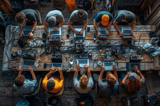 A group of people are gathered around a long wooden table using laptops. The room is filled with Automotive tire, Font, Art, Metal, Calabaza decorations