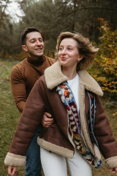 Man and woman outdoors, happy adult couple spendint time together in autumn park
