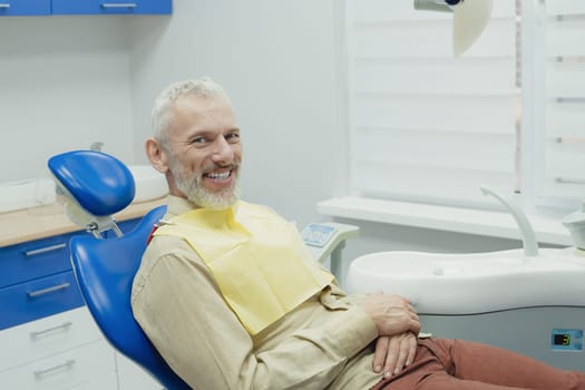 Male smiling during her dental treatment at dentist.