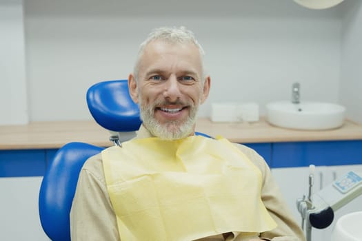 Male smiling during her dental treatment at dentist.