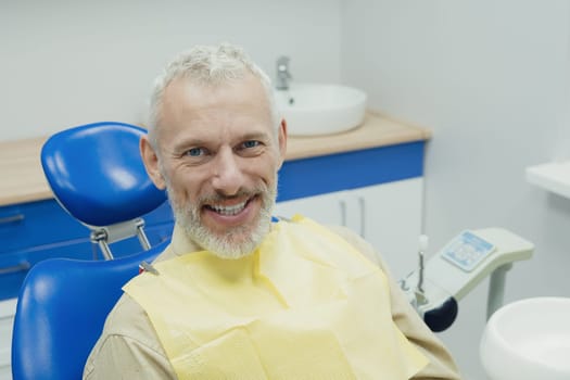 Male smiling during her dental treatment at dentist.