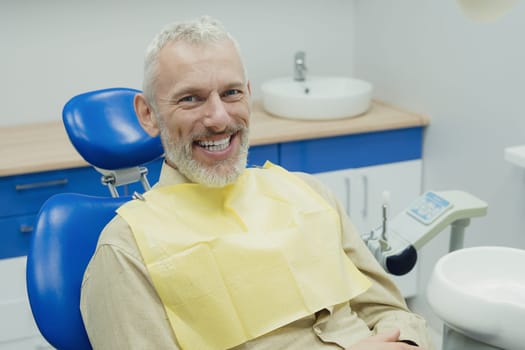 Male smiling during her dental treatment at dentist.