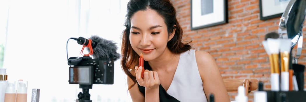 Asian Woman influencer shoot live streaming vlog video review makeup uttermost social media or blog. Happy young girl with cosmetics studio lighting for marketing recording session broadcasting online