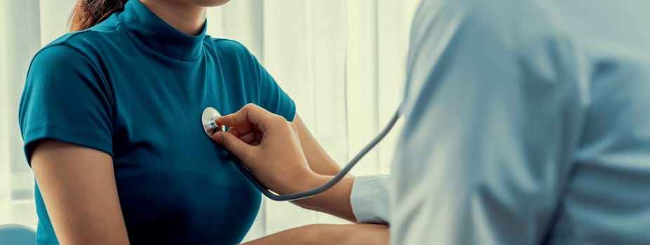 Patient attend doctor's appointment at clinic or hospital office. Doctor examining and diagnosis symptoms while checking the patient's pulse with stethoscope. Panorama Rigid