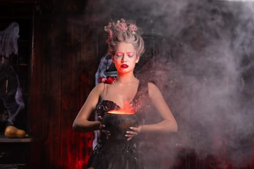 Halloween witch with cauldron. Beautiful young woman conjuring, making witchcraft. Standing spooky dungeon dark room. Enchantress prepare love potion use magic spell