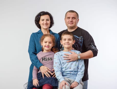 studio portrait of a happy family husband wife daughter and son 4