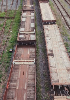 Freight trains on the railway station. Wagons with goods on railroad. Heavy industry. Industrial conceptual scene with trains.