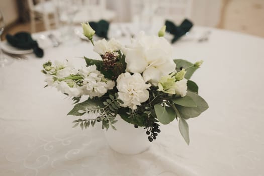 Wedding decor on the table. A bouquet of fresh flowers.