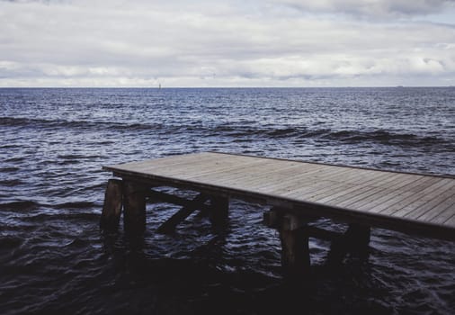 Wood bridge or pier on the beach and sea