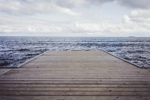 Wooden pier, sea and a blue sky. Beautiful background. Minimalism