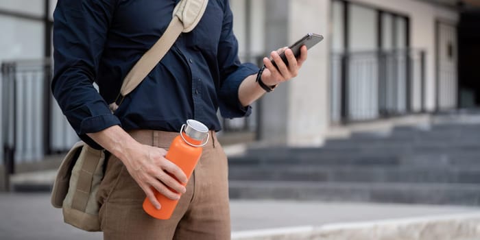 Businessman walking to work while to hold reusable eco friendly ecological cup in the city.