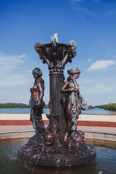 bronze fountain in the summer Park against the sky