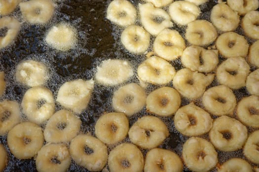 A close-up view of delicious buñuelos sizzling in hot oil, capturing the essence of traditional Spanish cuisine.