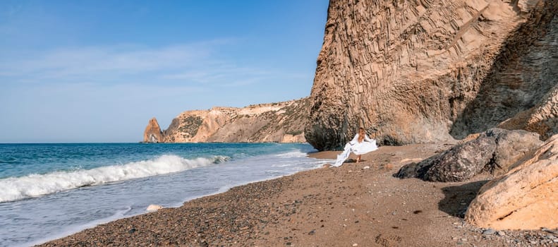 Woman beach white dress flying on Wind. Summer Vacation. A happy woman takes vacation photos to send to friends