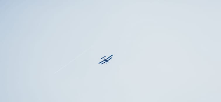 a small plane flies in a clear blue sky