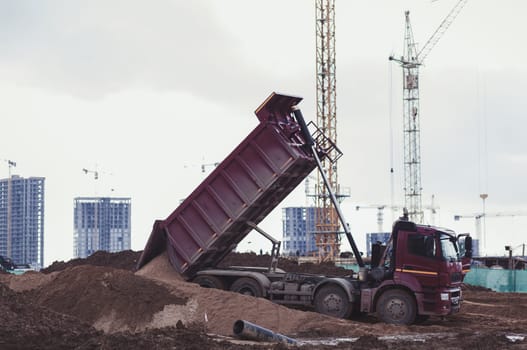 dump truck is dumping sand on construction site