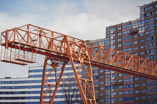 large yellow crane on the background of a new house under construction