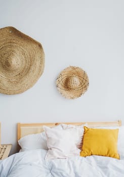 the interior of the modern bedroom with bright pillows and old straw hats