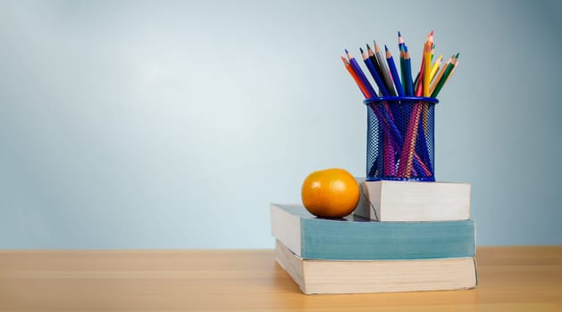 Stack of colorful textbooks and a glass of bright pencils on a white background, Concept of education, training, School tools, workspace, copy space, Banner design education concept background.