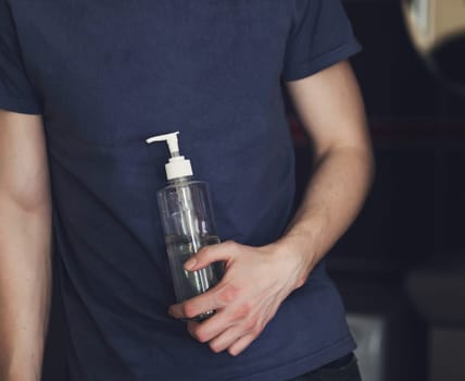 man is holding an antibacterial hand gel. protection from coronavirus. hygiene and health