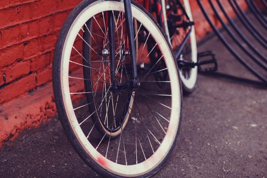 Two bicycles parked next to industrial red building