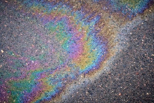 Textured stain of fuel or oil on wet asphalt on a rainy day. The concept of environmental pollution.