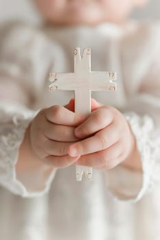 Baptism of a child cross in hands. Selective focus. Kid.