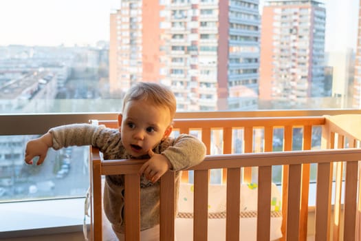 the baby looks interestedly inside the room, not paying attention to the landscape outside the