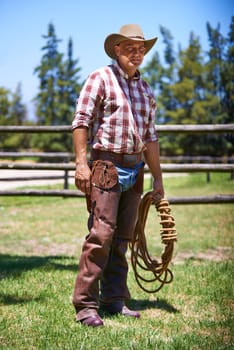 Farm, ranch and portrait of senior cowboy with rope lasso for horse, cows and rodeo animals for agriculture. Farming, nature and mature man in environment, countryside and working outdoors in Texas.