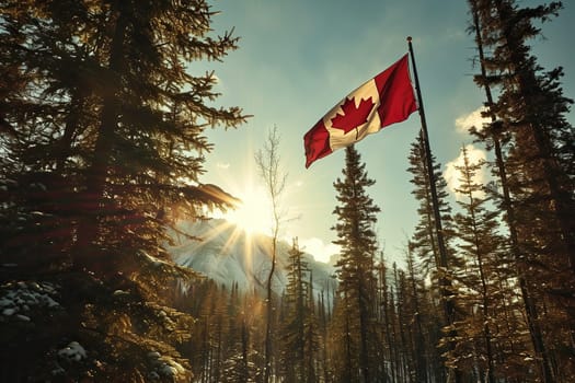 Canadian flag on a high pole among the forest against the backdrop of mountains and the sun.