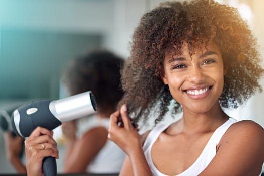 Black woman, hairdryer and hair with texture in portrait, curly hairstyle or frizz for morning routine in bathroom. Natural beauty, haircare and heat treatment for growth, shine and cosmetics at home.