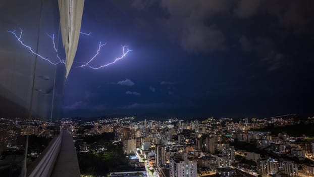 Lightning illuminates city at night, casting a striking scene.