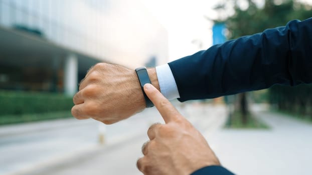 Closeup of professional businessman hand show smart watch and pointing the times. Professional boss, ceo, leader checking time from top view with city view. Business. Blurred background. Exultant.