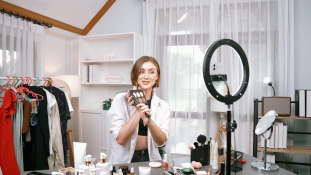 Woman influencer shoot live streaming vlog video review makeup prim social media or blog. Happy young girl with cosmetics studio lighting for marketing recording session broadcasting online.