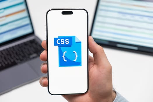 PRAGUE, CZECH REPUBLIC - JANUARY 21 2024: CSS logo on the screen of smartphone in mans hand on the workplace background.