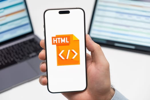 PRAGUE, CZECH REPUBLIC - JANUARY 21 2024: XXX logo on the screen of smartphone in mans hand on the workplace background.