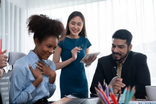 Happy diverse business people work together, discussing in corporate office. Professional and diversity teamwork discuss business plan on desk with laptop. Modern multicultural office worker. Concord