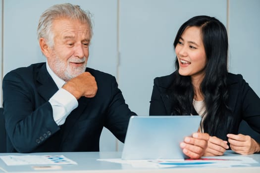 Senior executive manager and young businesswoman working in meeting room in the office. The woman is secretary or translator. International business language translation concept. uds