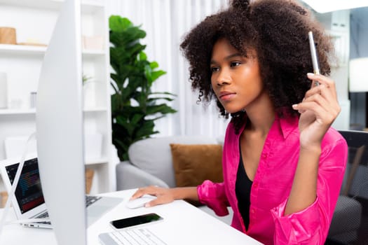 Working African woman blogger concentrated on the laptop screen with serious face, searching marketing data analysis, conclusion overall document on database for meeting report. Tastemaker.