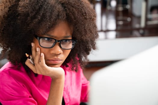 Portrait of young African woman creating website developer, thinking data information designer at home office, focusing on laptop. Concept of analytical data center in java project job. Tastemaker.