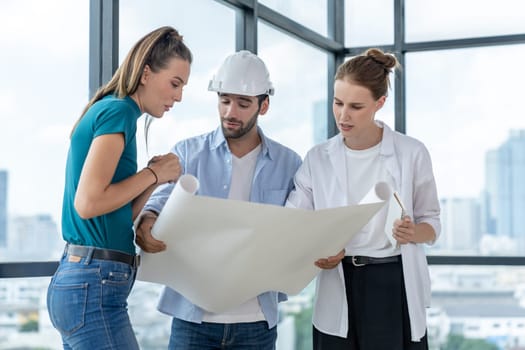 Group of architect engineer looking at project plan while brainstorming idea about building structure. Manager team discuss about building construction while standing near with city view. Tracery.