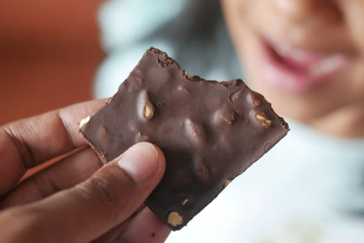 child eating dark chocolate close up .