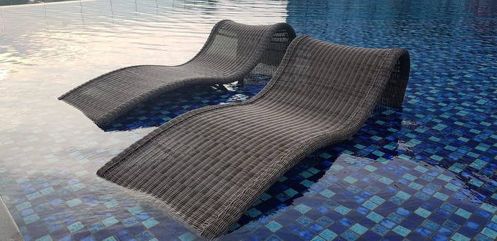 relax deck chair by the blue pool at swimming pool in luxury spa resort or villa Tourism industry crisis after covid 19 coronavirus pandemic Travel lifestyle on family summer vacation