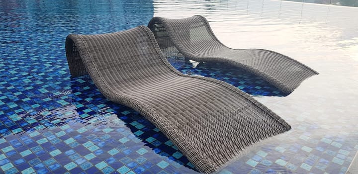 relax deck chair by the blue pool at swimming pool in luxury spa resort or villa Tourism industry crisis after covid 19 coronavirus pandemic Travel lifestyle on family summer vacation