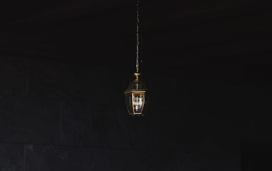 Modern style gold decoration lamp against dark wall.