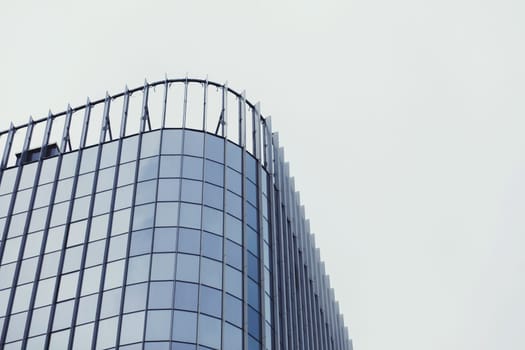 Glass modern office building on sky background