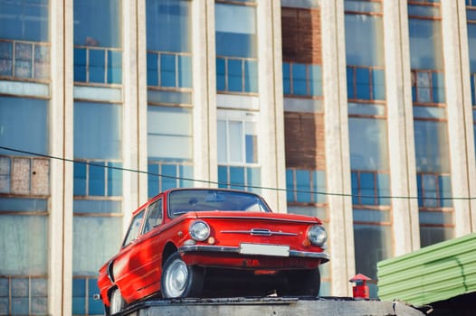 Minsk, Belarus - August  2019. Colorful red soviet retro car near old building. 