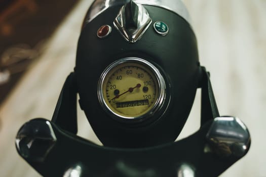 Vintage motorcycle tachometer with chrome ring and white dial.